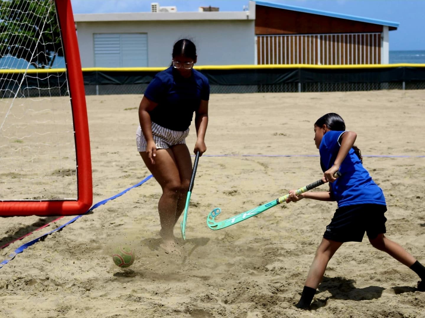 Acción de infantiles y adultos en el hockey de playa del Festival Olímpico